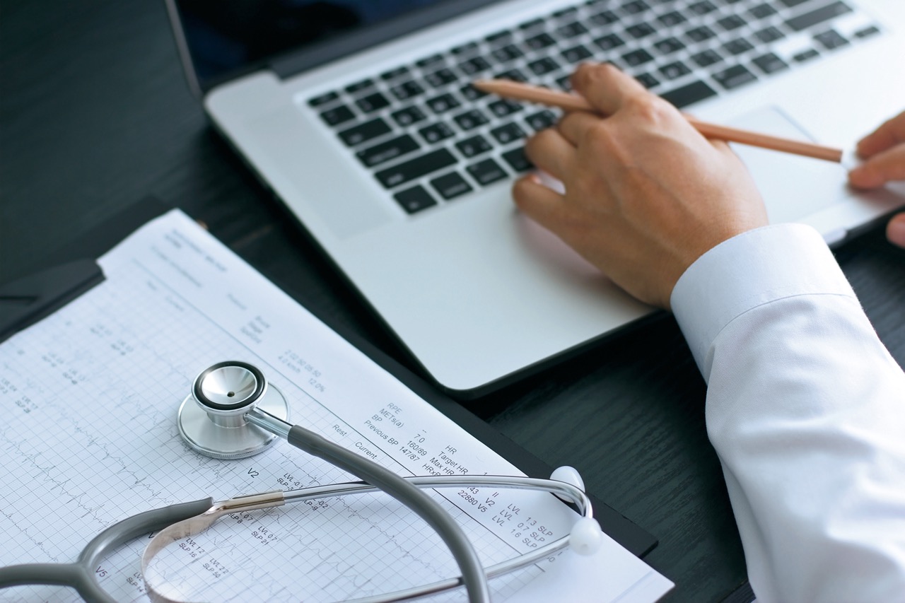 Doctor uses computer to review patient notes.