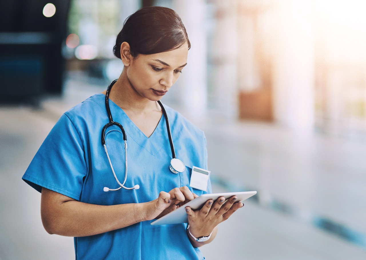 Nurse uses tablet to review patient notes